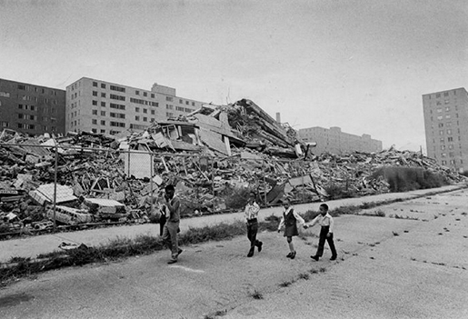 Children waling in front of ruins